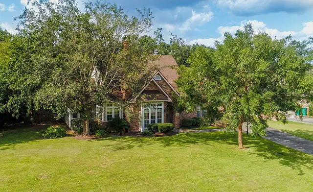 Aerial pictures taken by a drone of a house. Big yard surrounded by tall trees