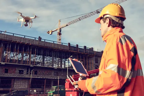 man flying a drone in a building development wearing secure wear
